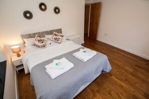 A neatly made bed with pillows and a folded towel on the bed. - 4 Bed Flat - Sleeps 10 - Pets - Parking (London)