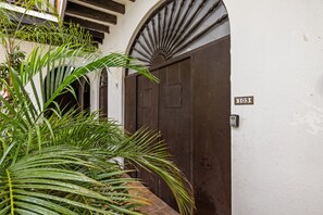 Un edificio tradicional con una puerta de madera oscura y una pequeña placa que indica el número 103.