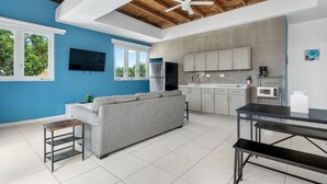Una cucina moderna con mobili grigi, un frigorifero in acciaio inossidabile e un forno a microonde.