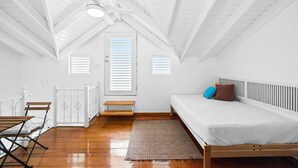 A bedroom with a wooden bed, a bench, and a small table. - Beachfront With Pool Free Parking (Aguada)