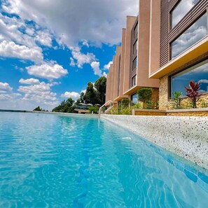 A modern hotel with a pool, clear blue water, and a view of the ocean. - Humphreys Hill House (Kisii)