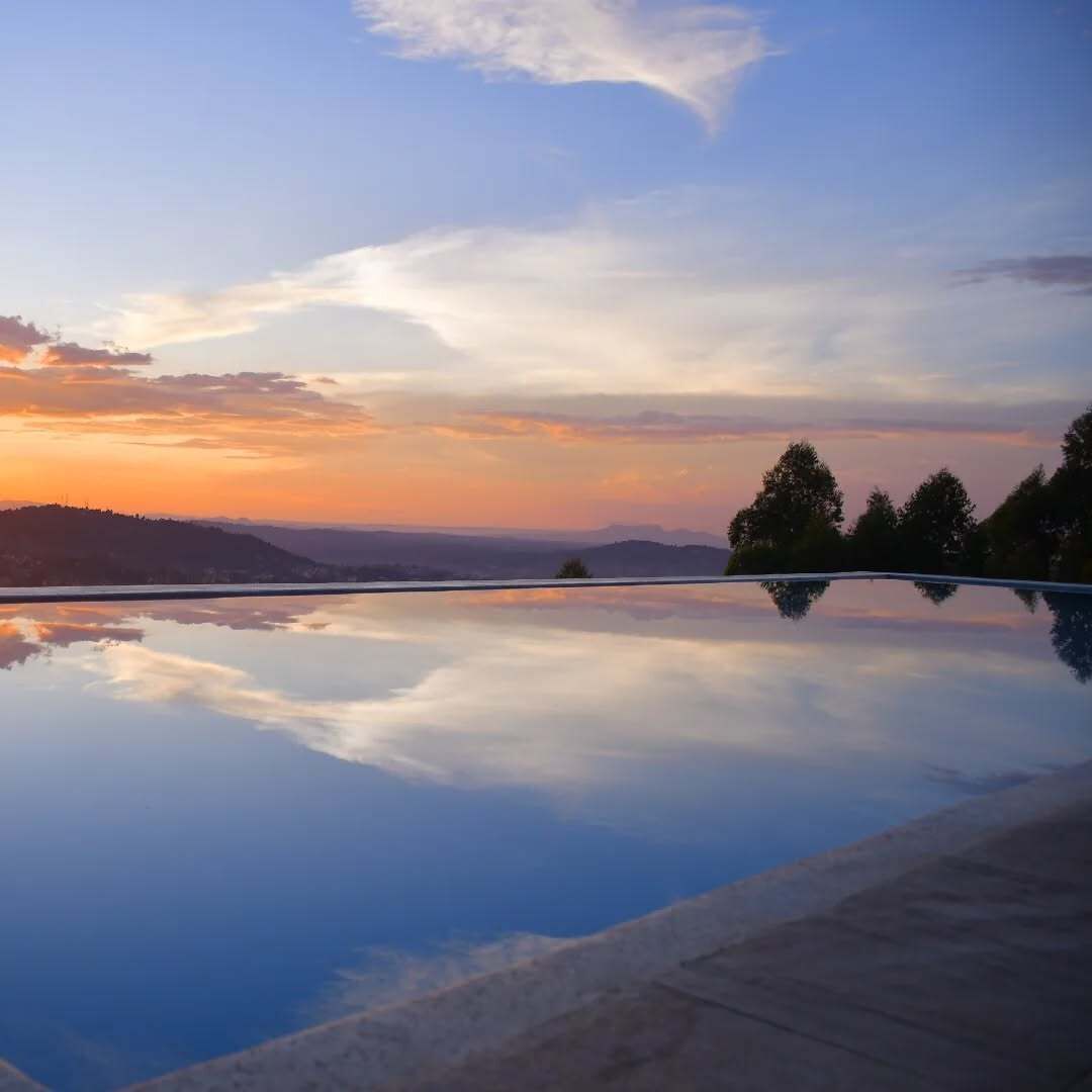 Vista despejada de una piscina con montañas y árboles al fondo.