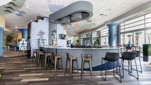 Un área de bar moderna con una barra curva, varios taburetes y vistas al espacio exterior.
