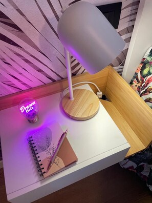 A bedside table with a lamp, a notebook, and a pen. - FLORIDA 7 (Pertegada)