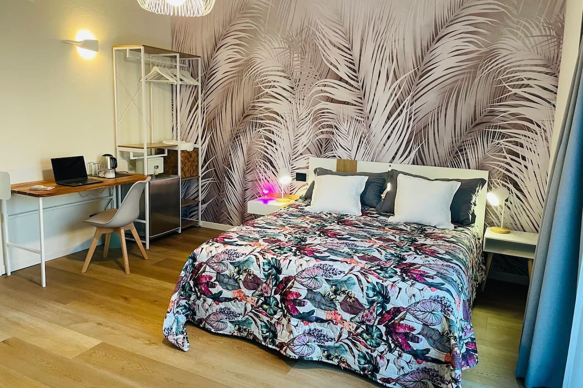 A bedroom with a bed, a desk, and a chair.