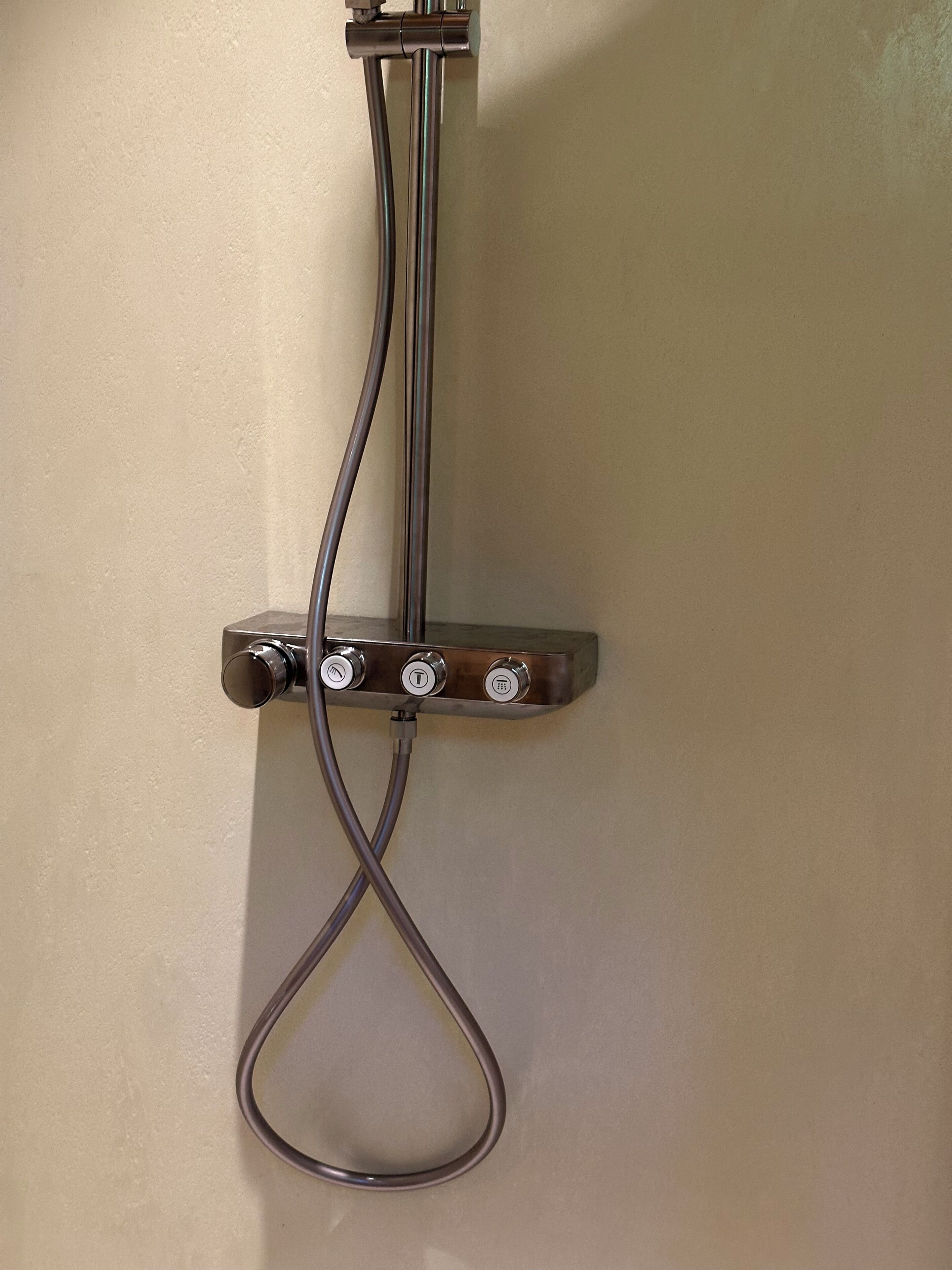 Une douche équipée d’un pommeau amovible et d’un flexible.