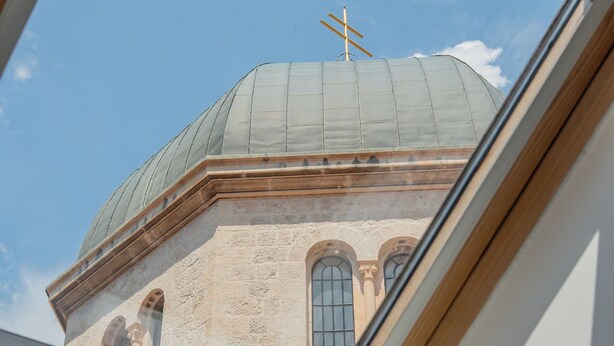 A skylight view of a building with a dome and arched windows. - Old Town Church Bells (Kotor)