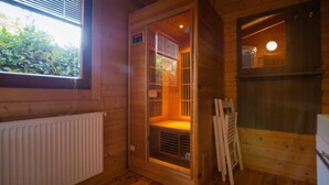 Un sauna avec des murs en bois, une fenêtre et un radiateur.