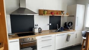 Una cocina moderna con estufa, horno, fregadero y encimera de madera.