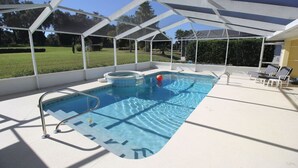 A covered outdoor swimming pool with a hot tub, lounge chairs, and a clear view of the surrounding greenery. - Inverness Florida 4BR Pool Home & Spa – Near Ocala, Crystal River & Floral City (Inverness)