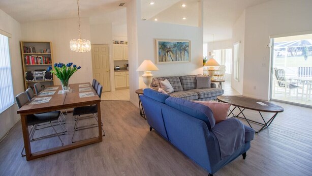 A spacious living area with a dining table, sofa, and a view of the outdoors. - Inverness Florida 4BR Pool Home & Spa – Near Ocala, Crystal River & Floral City (Inverness)