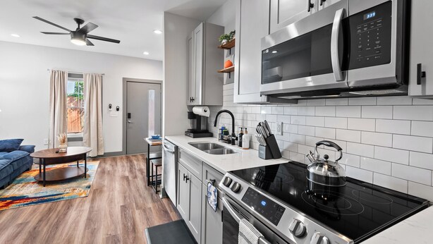 A modern kitchen with stainless steel appliances, a gas stove, and a microwave.