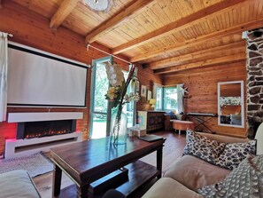 A cozy cabin interior with a fireplace, wooden walls, a stone accent wall, and a comfortable seating area. - Fairy Tale Cottage on Water Stream, 30 Minutes From South Prague (Petrov)