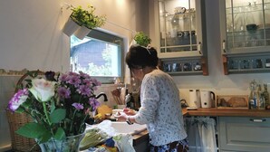 Una cocina con vigas de madera, una ventana y un lavabo.