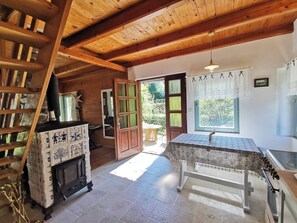 A rustic wooden interior with a fireplace, a dining table, and a view of the outdoors. - Fairy Tale Cottage on Water Stream, 30 Minutes From South Prague (Petrov)