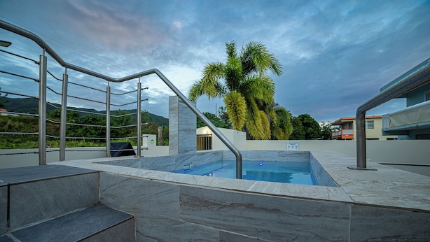 A swimming pool with steps leading up to it, surrounded by a metal railing and a stone wall. - Jesus did it, Christian Paradise with jacuzzi, terrace, and peaceful atmosphere. (Patillas)