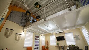 A multi-level living space with a balcony, ceiling fans, a flat-screen TV, and a dining area with wicker furniture. - Jesus did it, Christian Paradise with jacuzzi, terrace, and peaceful atmosphere. (Patillas)