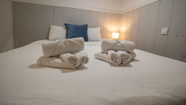 A hotel room with a neatly made bed, pillows, and a lamp. - Apartment Duplo 08 (Madrid)