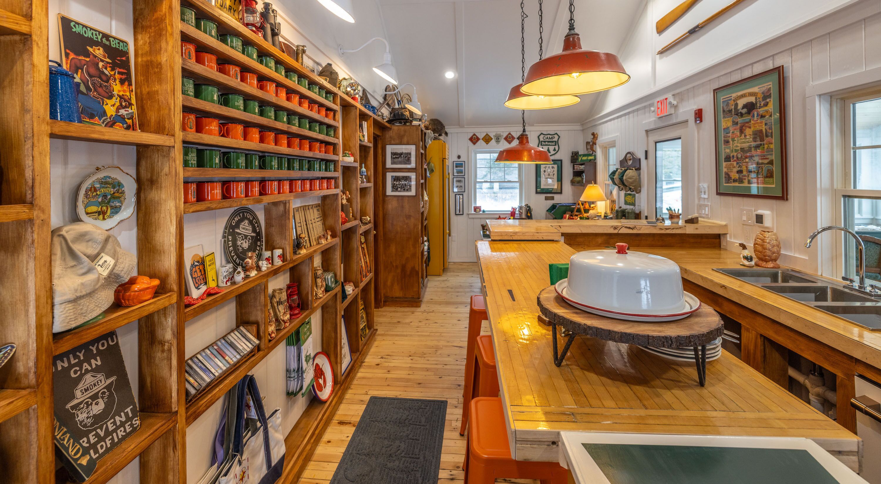 A kitchen with wooden shelves, a central island, and a dining area.