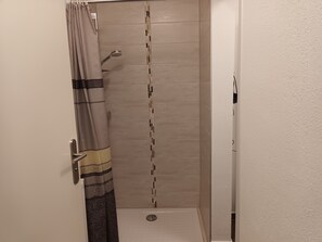 Een douche, een haardroger, handdoeken, toiletpapier