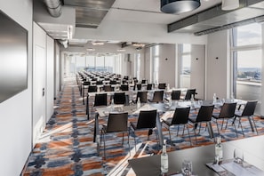 A conference room with rows of tables and chairs, large windows, and a patterned carpet. - Aiden by Best Western Velbert (Velbert)