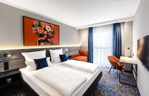 A hotel room with a bed, a desk, a chair, a TV, and a painting on the wall. - Aiden by Best Western Velbert (Velbert)