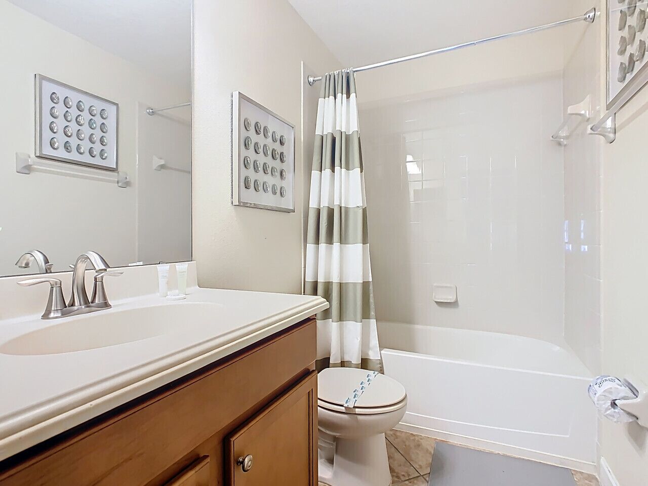 A bathroom with a sink, mirror, toilet, and shower.