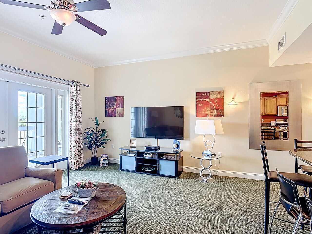 A living room with a sofa, coffee table, TV, and a dining area with chairs and a table.