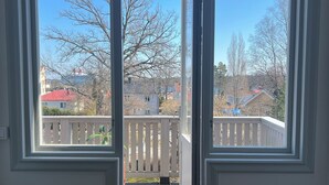 Une pièce dotée d’une grande porte-fenêtre coulissante qui donne sur une terrasse en bois.