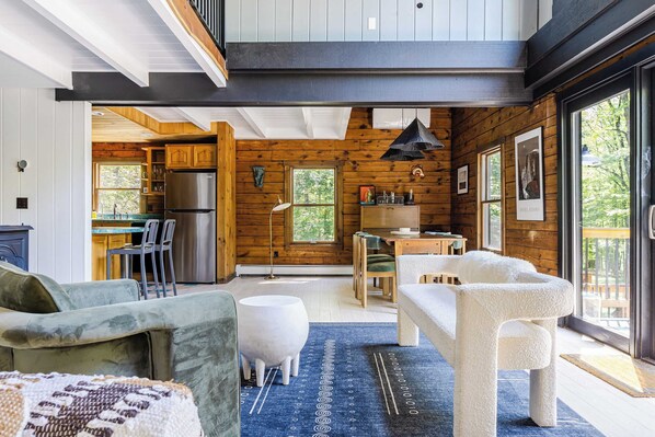 A modern cabin interior with a kitchen, dining area, and seating space. - Pool+hot Tub, Firepit Near Hikes, Shops, Dining Cragswood Lodge by Avantstay (New Paltz)
