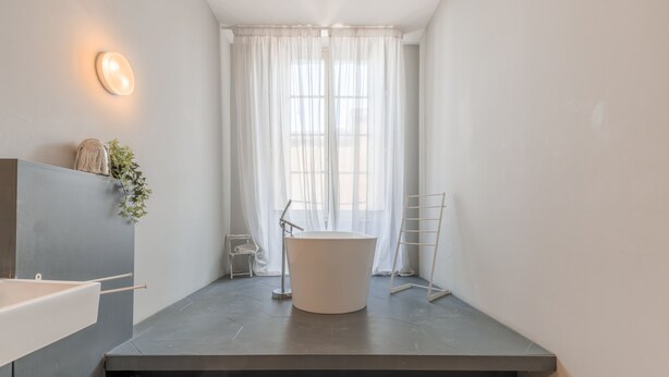 A modern bathroom with a freestanding bathtub, a white sink, and a towel rack. - Cozy Elegant 2BR Apartment (Valletta)
