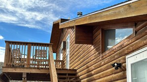 Une cabane en bois dotée d’une terrasse en bois, d’un escalier et d’une fenêtre.