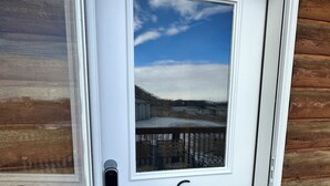Une porte blanche avec un panneau de verre, une poignée en métal et un trou de serrure.