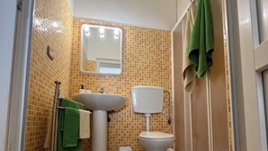A bathroom with a tiled floor, a sink, a toilet, and a mirror. - Marzamemi Beach Sun Sea vacation home (Marzamemi)