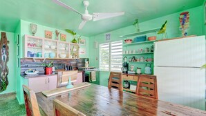 A kitchen with wooden furniture, a ceiling fan, and various kitchen appliances. - LoveSoulBeautiful (Luquillo)