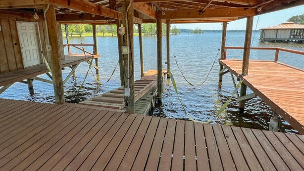 A wooden dock extending over water, with a covered area and a door.