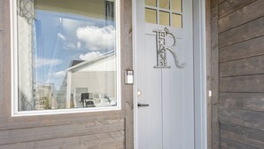 Een houten deur met een wit paneel en een groot ‘R’ bord.