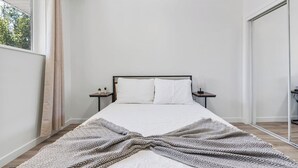 A bedroom with a bed, two bedside tables, a window with curtains, and a mirror. - Cozy Salt Lake Getaway - Desk w/ Monitor ! (Salt Lake City)