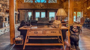 Un interno rustico con una scrivania in legno, un divano in pelle e una scultura di un orso.