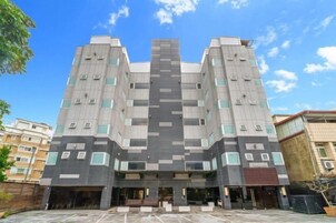 Un edificio moderno de varios pisos con fachada simétrica, amplias ventanas y una entrada central.