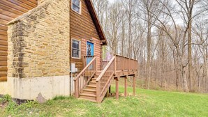 A rustic log cabin with a wooden staircase leading to a porch. - 8 Mi to IU: Cabin w/ Reading Nook, Fire Pit & Yard (Unionville)