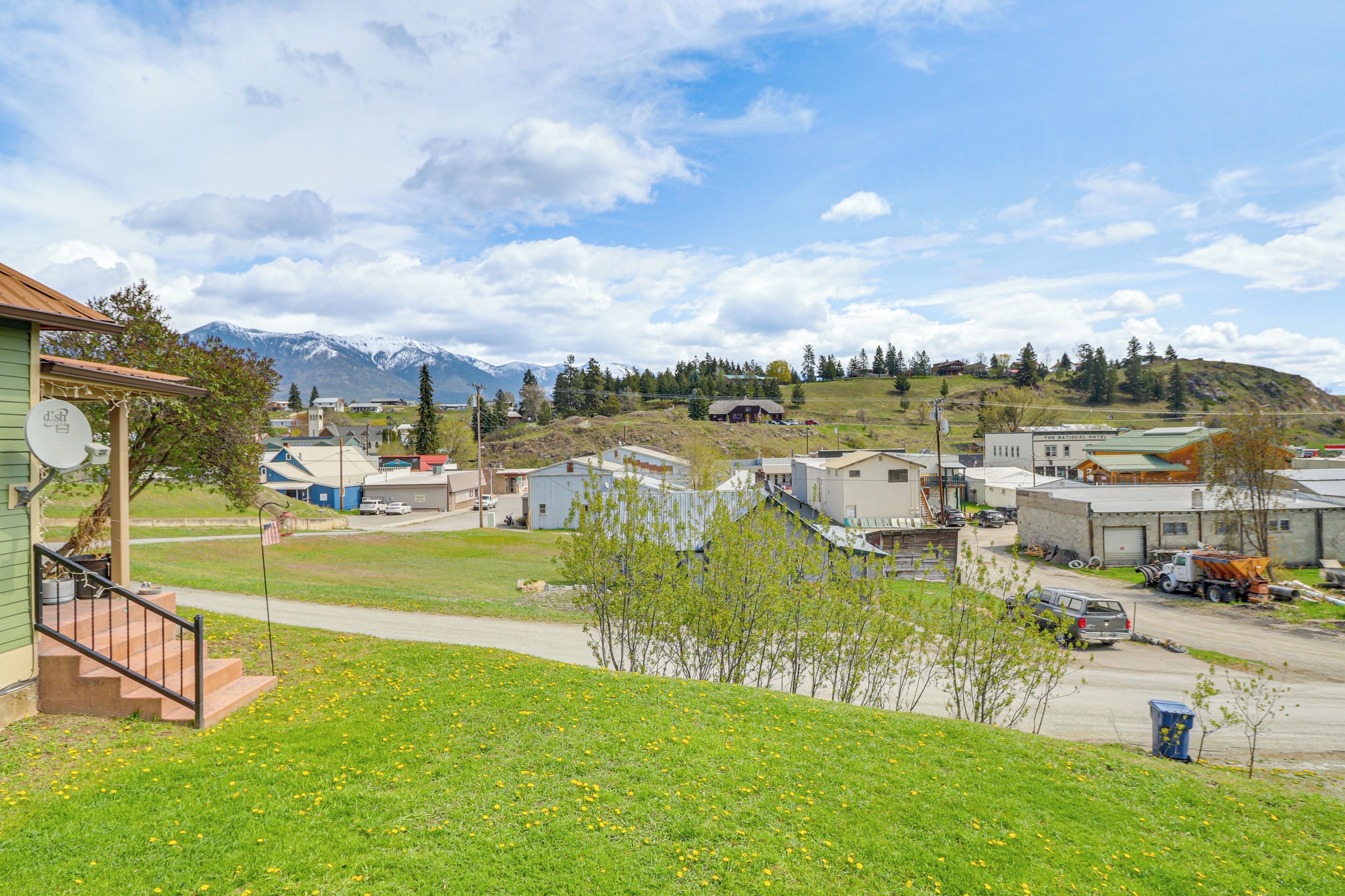 A residential area with houses, a road, and a mountain range in the background.