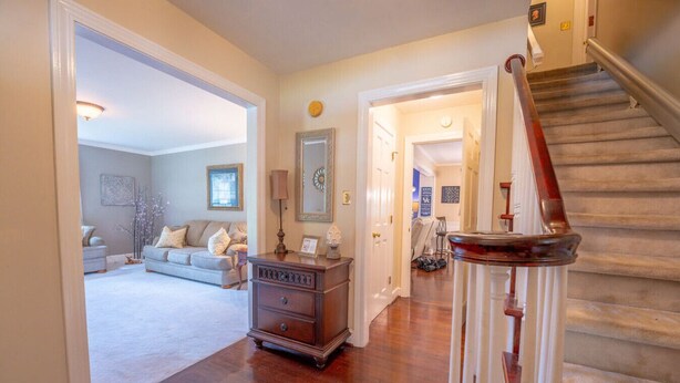 A spacious living room with a wooden staircase and a cozy seating area.