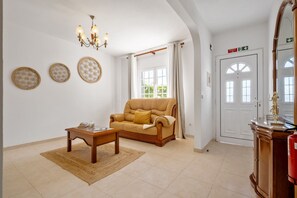Un salon comprenant un canapé, une table basse et des éléments décoratifs fixés au mur.