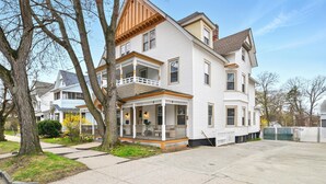 Une maison à deux étages avec un porche à l’avant, une véranda couverte et un garage.