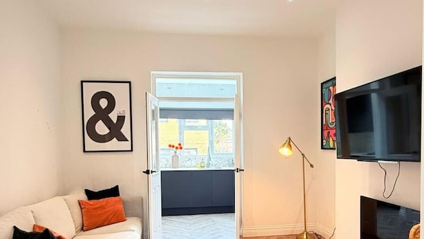 A modern living room with a sofa, a television, and a herringbone-patterned floor. - Stylish apartment close to center zone 2, London, UK (London)