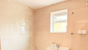 A bathroom with a bathtub, sink, toilet, and a window. - Stylish apartment close to center zone 2, London, UK (London)