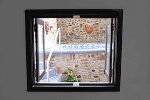 Enjoy a serene view from this room's window, featuring a decorative stone wall and a charming table setting.