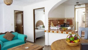 A living room with a turquoise sofa, a wooden coffee table, and a wicker fruit basket on a round table. - Hacienda Vallarta - Los Muertos Beach (Puerto Vallarta)
