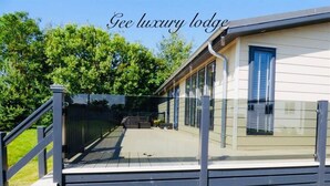 A luxury lodge with a wooden deck and a covered outdoor area.